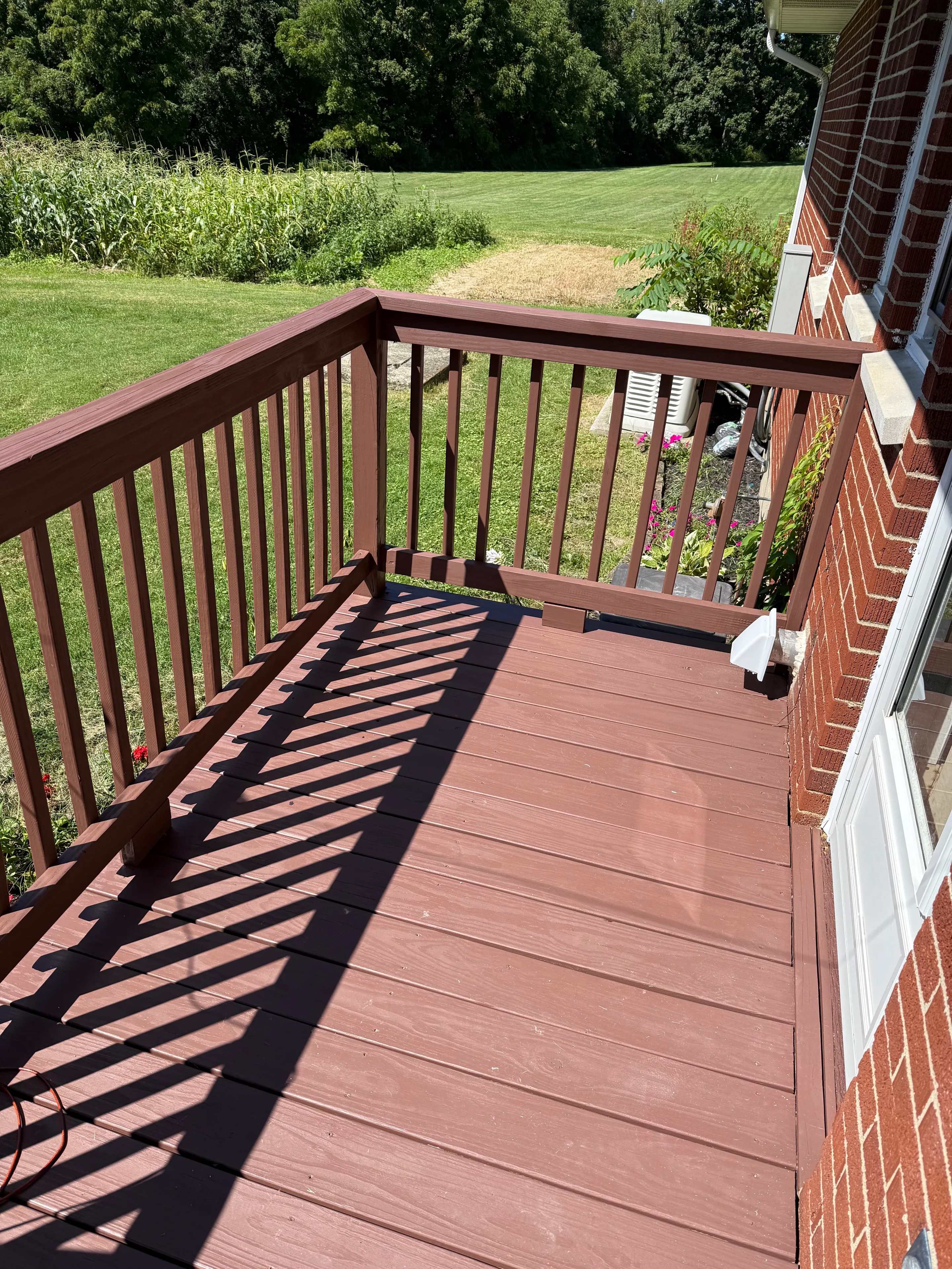 Finished deck boards and railing overlooking the yard